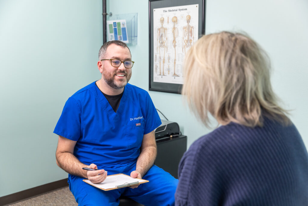 Back of woman's head as she sits with a neck specialist in North Liberty to discuss the cause of neck pain and treatment options available
