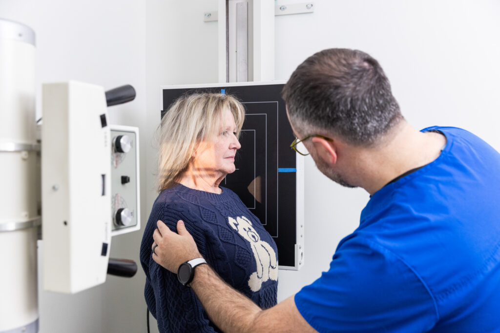 Women stands on scale as medical professional instructs her where to look so they can find the root of symptoms through Functional Medicine in North Liberty