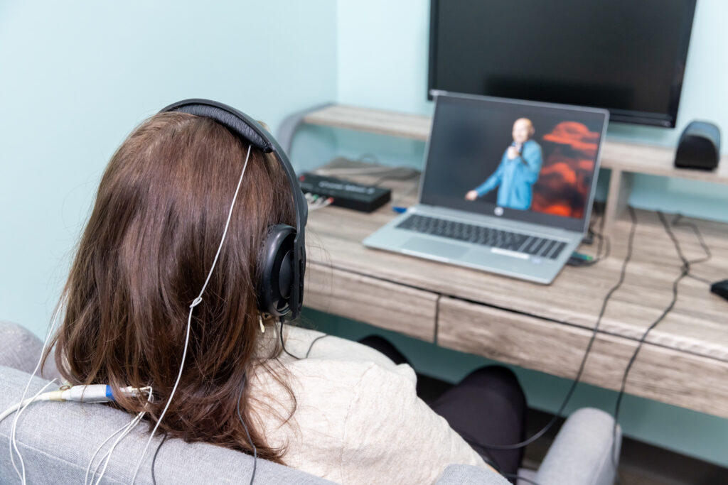 Patient watching a screen with electrodes on her head during an appointment for neurofeedback. This is a treatment for functional medicine in North Liberty that retrains your brain to help it function optimally.