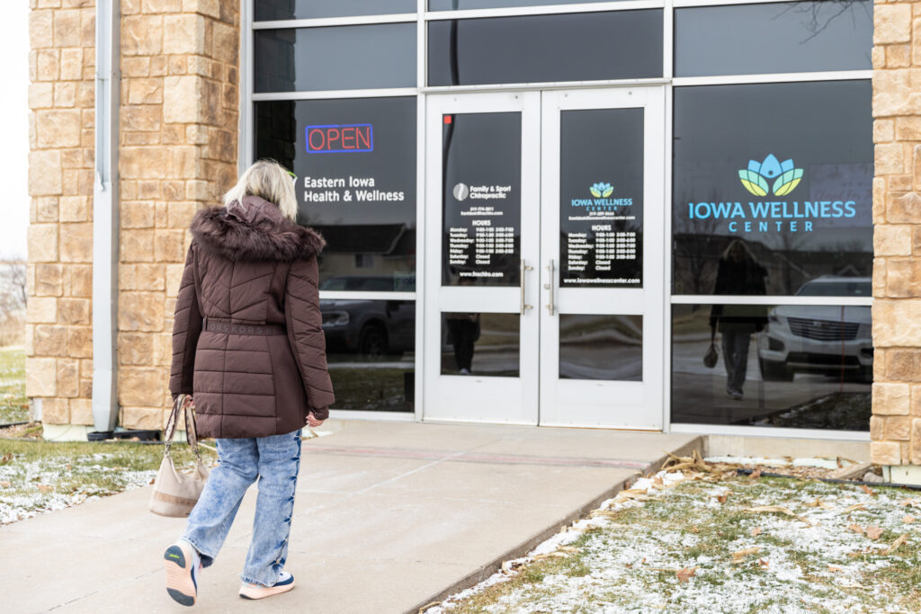 Woman walking into a chiropractic center to receive chiropractic care for pregnancy near Iowa City.