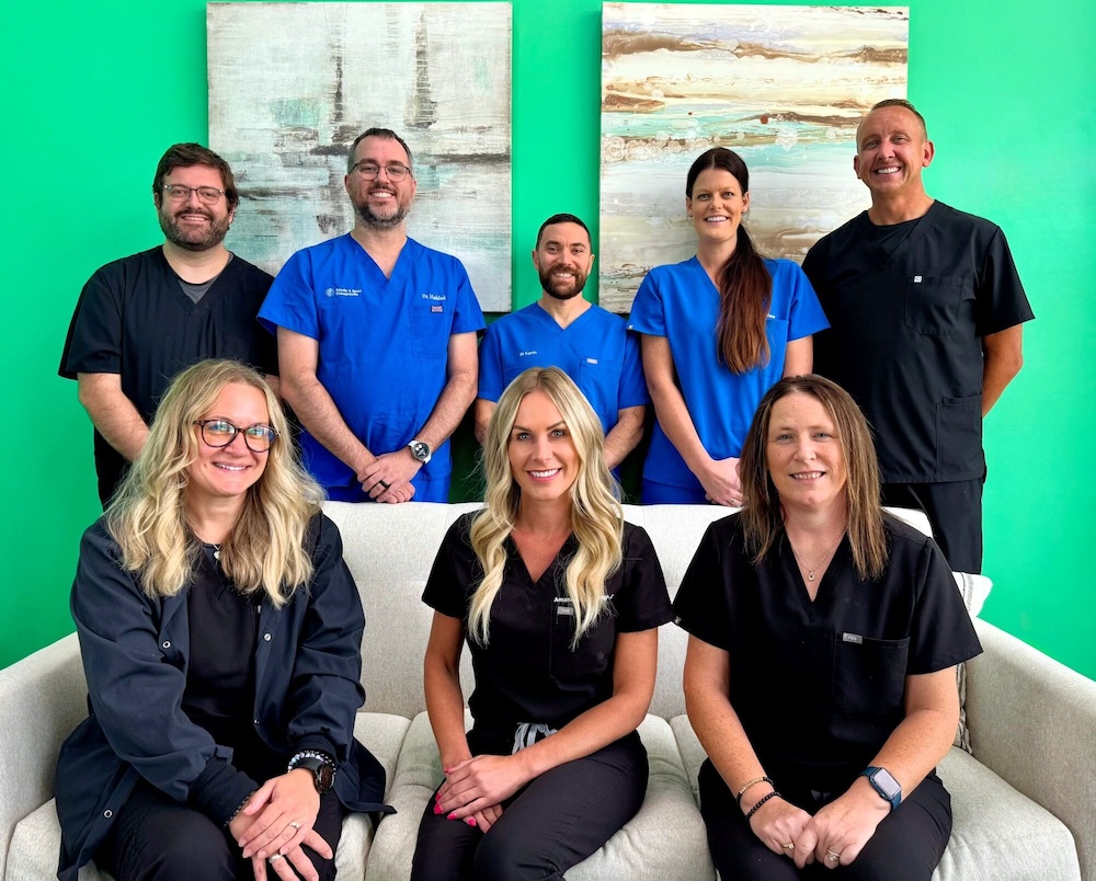 Chiropractors who provide patients with disc herniation treatment in North Liberty posing in front of a camera for a team photo.